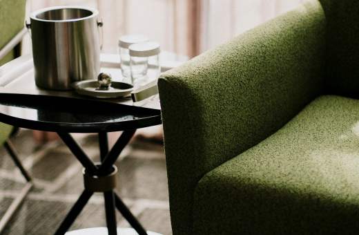 Groene fauteuil en bijzettafel in een hotelkamer